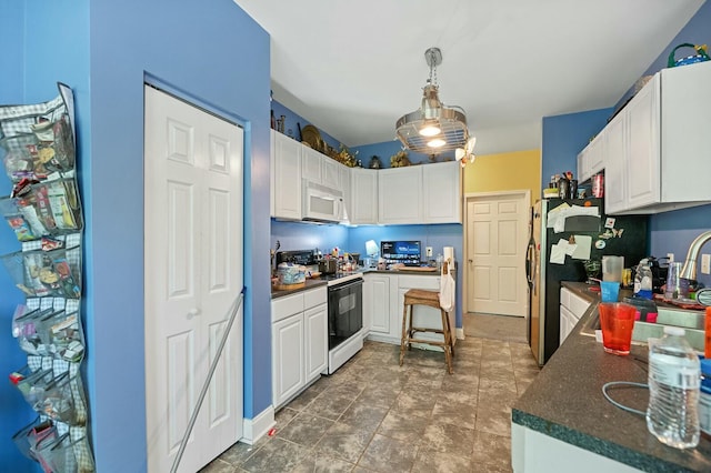 213 Travelers Rest Blvd, Summerville, SC 29485 - kitchen featuring white microwave, freestanding refrigerator, white cabinets, dark countertops, and range with electric cooktop