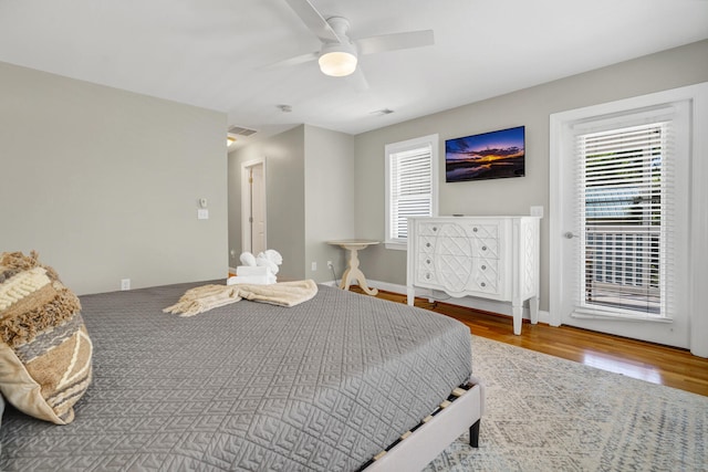 bedroom featuring hardwood / wood-style flooring, multiple windows, and ceiling fan