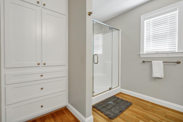 bathroom featuring hardwood / wood-style flooring and a shower with shower door