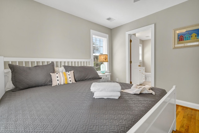 bedroom featuring hardwood / wood-style floors and ensuite bath