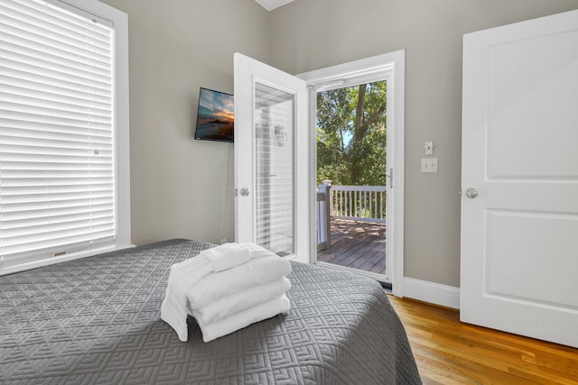 bedroom with access to outside and hardwood / wood-style floors