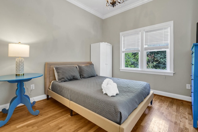 bedroom featuring crown molding, hardwood / wood-style floors, and a chandelier