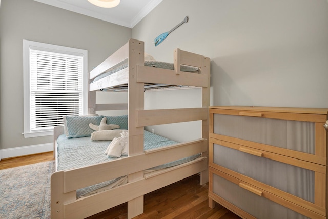 bedroom featuring hardwood / wood-style floors, crown molding, and multiple windows