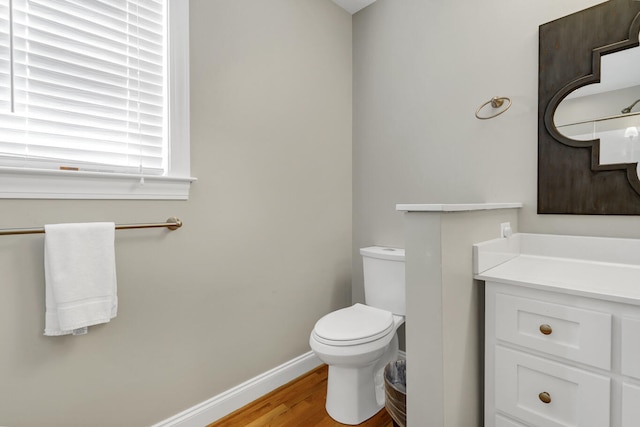 bathroom featuring vanity, wood-type flooring, and toilet