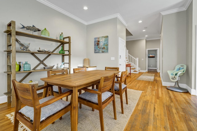 dining room featuring ornamental molding and light wood-type flooring