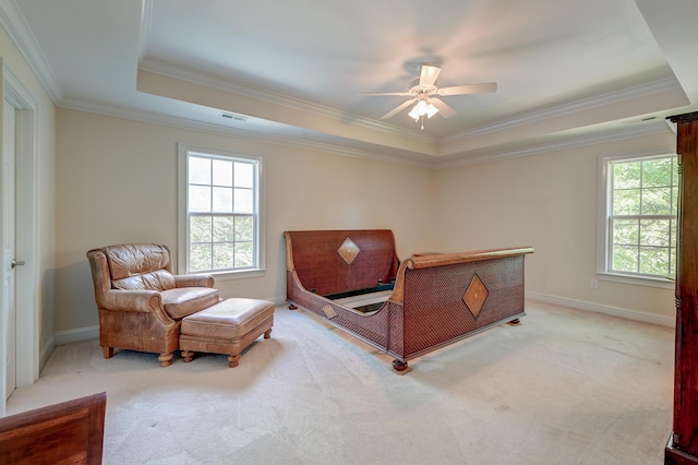 bedroom featuring a tray ceiling, light carpet, ornamental molding, and baseboards