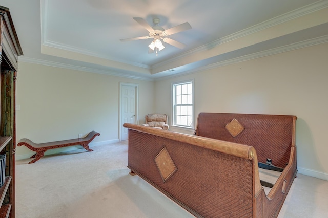 office with light colored carpet, a tray ceiling, a ceiling fan, baseboards, and ornamental molding