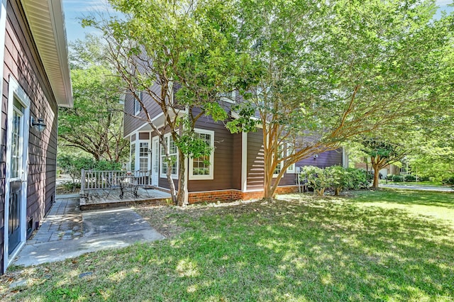 view of green lawn featuring a deck