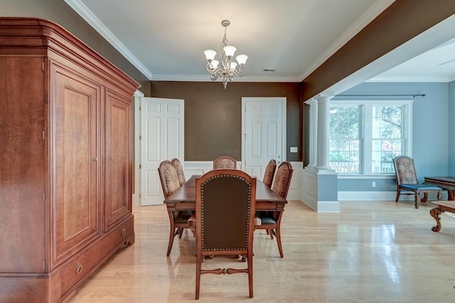 dining room with decorative columns, a chandelier, ornamental molding, light wood finished floors, and baseboards