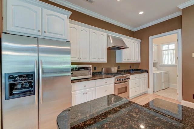kitchen with appliances with stainless steel finishes, wall chimney range hood, independent washer and dryer, white cabinetry, and ornamental molding