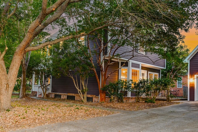 view of property exterior with crawl space and driveway