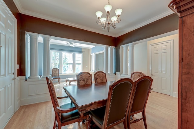 dining area featuring decorative columns, light wood-style floors, crown molding, a ceiling fan, and a chandelier