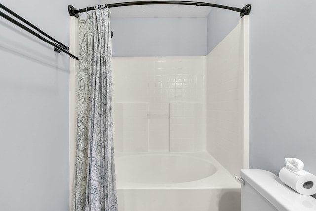 bathroom with shower / bath combination with curtain and toilet