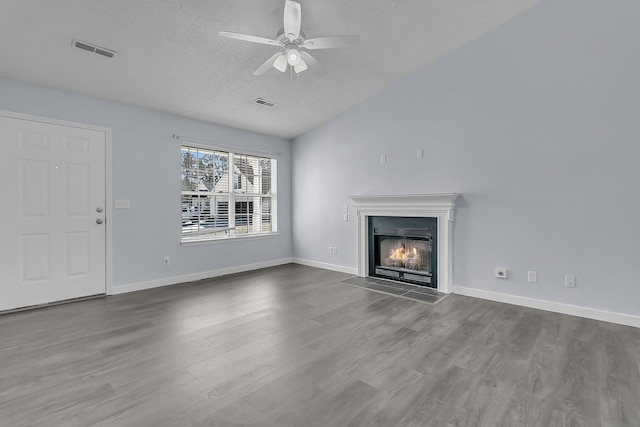 unfurnished living room featuring visible vents, a fireplace with flush hearth, and wood finished floors