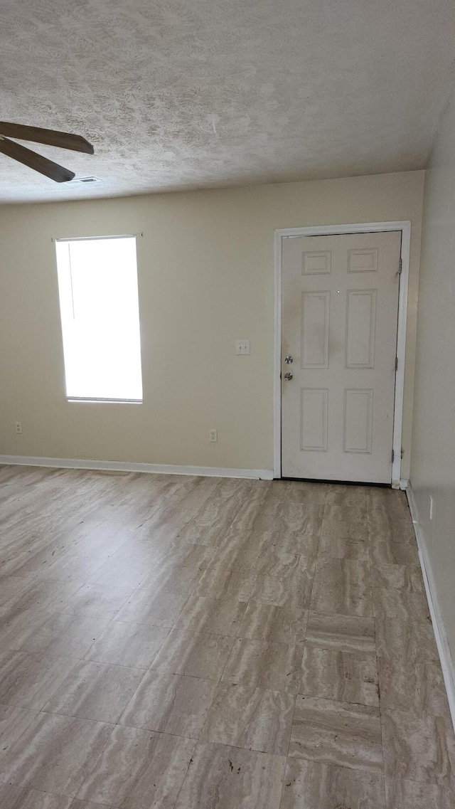 unfurnished room with ceiling fan, light hardwood / wood-style floors, and a textured ceiling