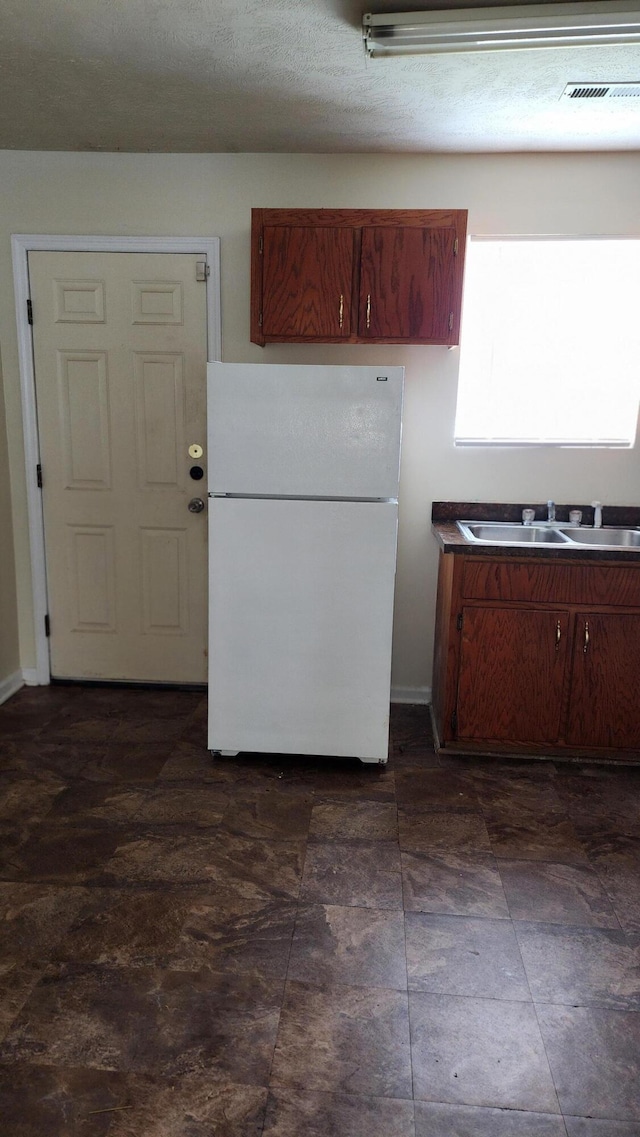 kitchen featuring sink and white fridge