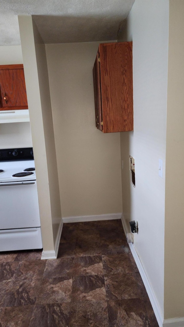 clothes washing area featuring cabinets and a textured ceiling