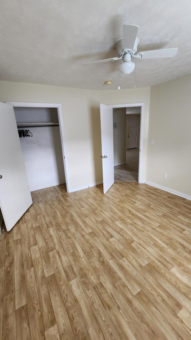 unfurnished bedroom featuring a textured ceiling, light hardwood / wood-style floors, a closet, and ceiling fan