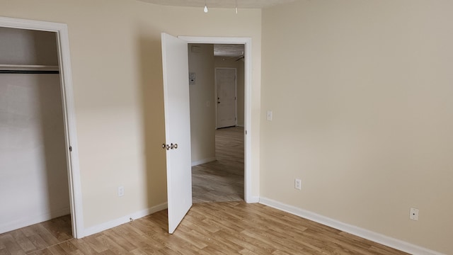 unfurnished bedroom featuring light hardwood / wood-style floors and a closet