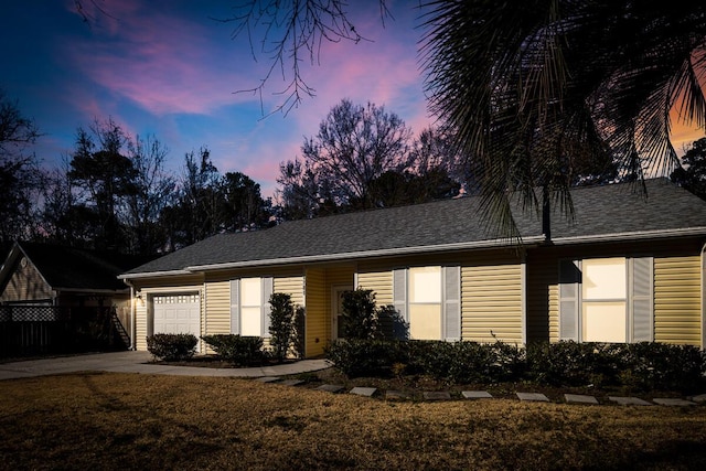 single story home featuring a shingled roof, an attached garage, and a front yard