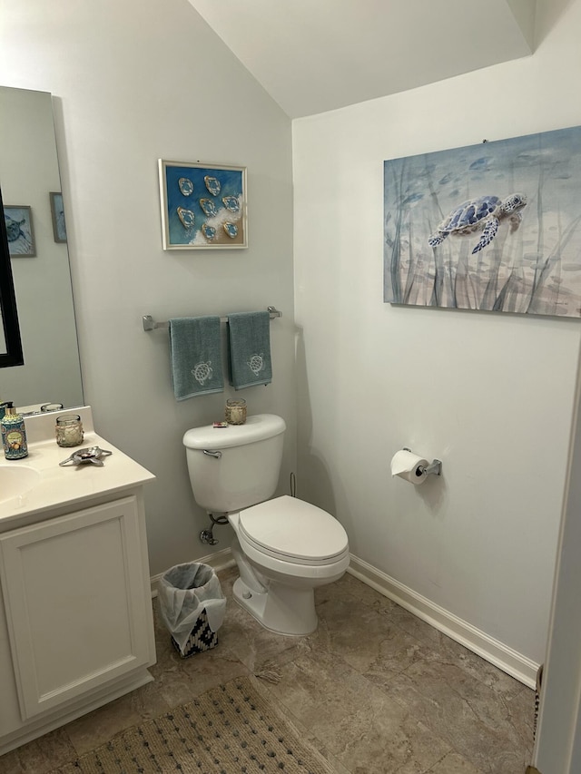 bathroom featuring lofted ceiling, toilet, and vanity