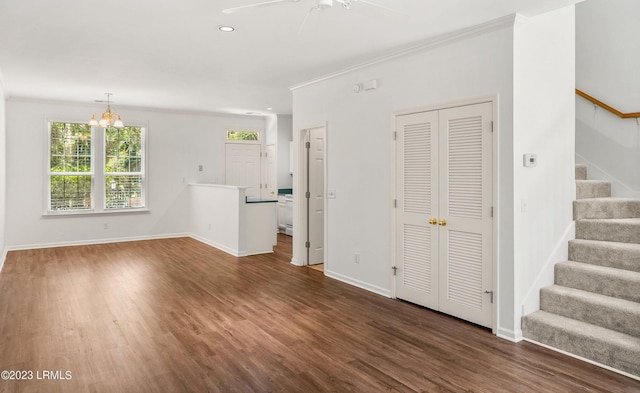 unfurnished living room featuring dark wood-type flooring, ornamental molding, and ceiling fan