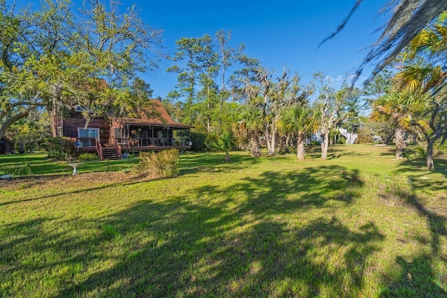 7897 Russell Creek Dr, Edisto Island, SC 29438 - view of green lawn featuring a wooden deck and a sunroom