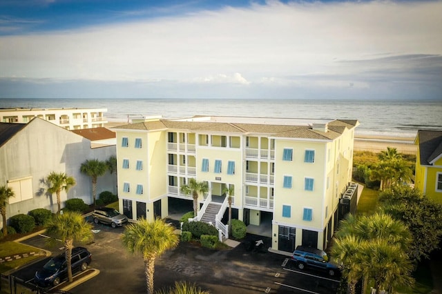 view of property with a water view and a view of the beach