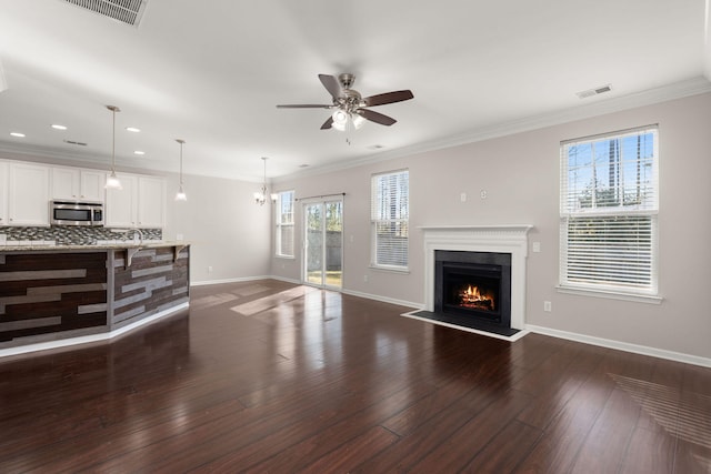 living room featuring ceiling fan, dark hardwood / wood-style floors, and crown molding