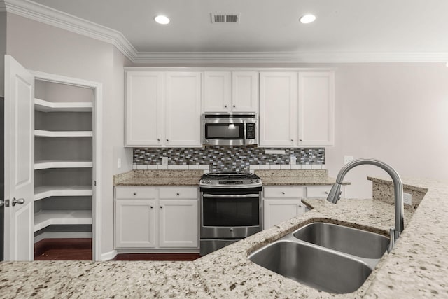 kitchen featuring light stone counters, sink, white cabinetry, and stainless steel appliances