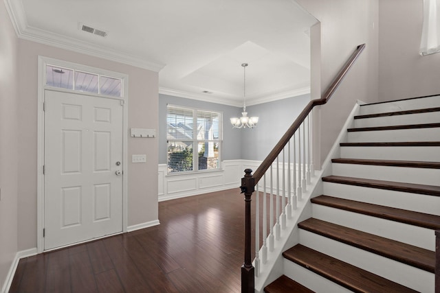 entryway featuring an inviting chandelier, dark hardwood / wood-style flooring, and crown molding