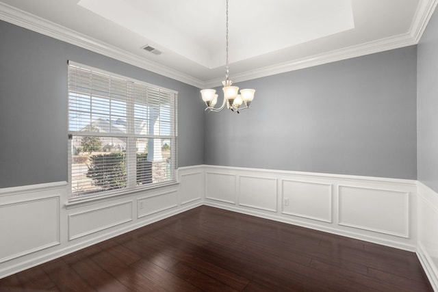 unfurnished room featuring a tray ceiling, dark hardwood / wood-style floors, and a chandelier