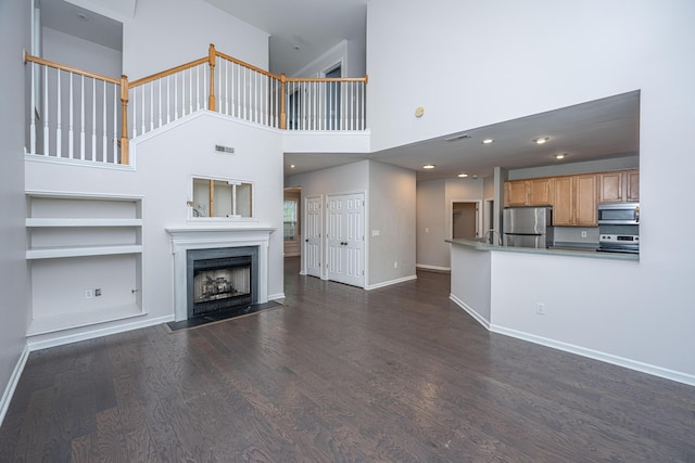 1629 Jorrington St, Mount Pleasant, SC 29466 - unfurnished living room featuring dark wood-style flooring, a fireplace with flush hearth, built in shelves, and a high ceiling