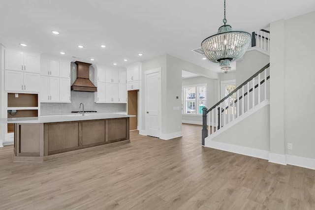 1183 Reserve Ln, Awendaw, SC 29429 - kitchen featuring custom range hood, a chandelier, white cabinets, light wood-style floors, and recessed lighting