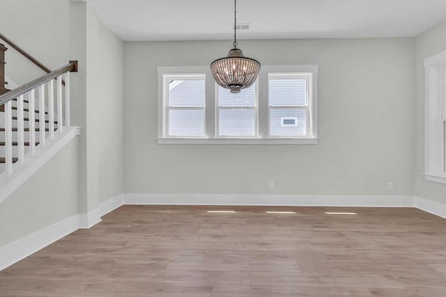 1183 Reserve Ln, Awendaw, SC 29429 - unfurnished dining area featuring a chandelier, wood finished floors, and stairs