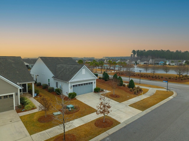 view of front facade with a garage and a water view