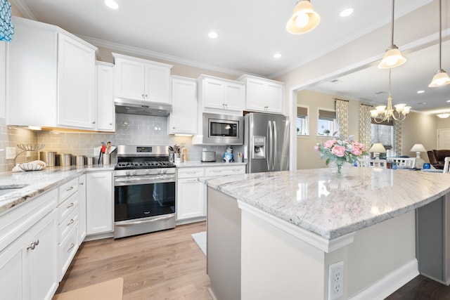 kitchen with hanging light fixtures, white cabinetry, appliances with stainless steel finishes, and a kitchen island