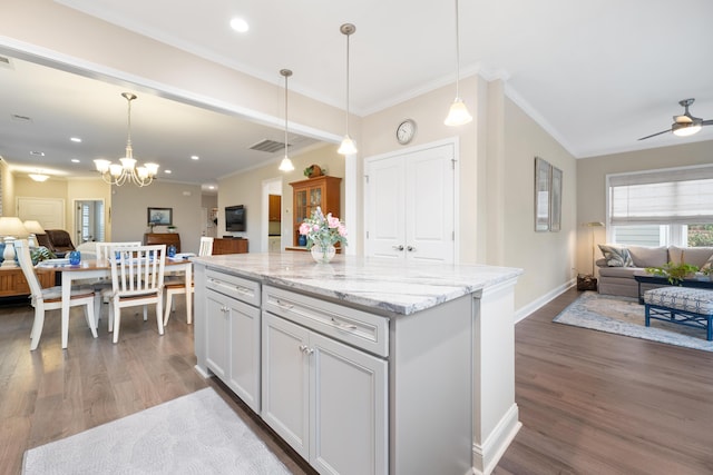 kitchen featuring hanging light fixtures, light stone countertops, and dark hardwood / wood-style floors