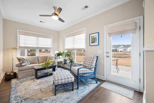 living room with ornamental molding, dark hardwood / wood-style floors, and ceiling fan