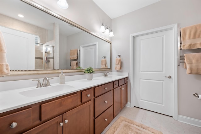 bathroom featuring tile patterned floors, a shower with shower door, and vanity