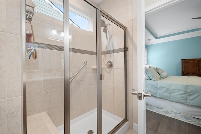 bathroom with crown molding, wood-type flooring, and a shower with shower door