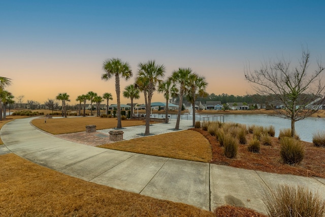 view of community with a lawn and a water view