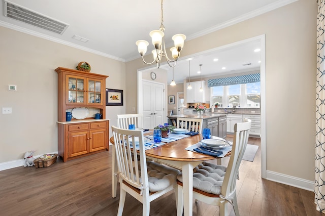 dining space with an inviting chandelier, hardwood / wood-style flooring, and ornamental molding