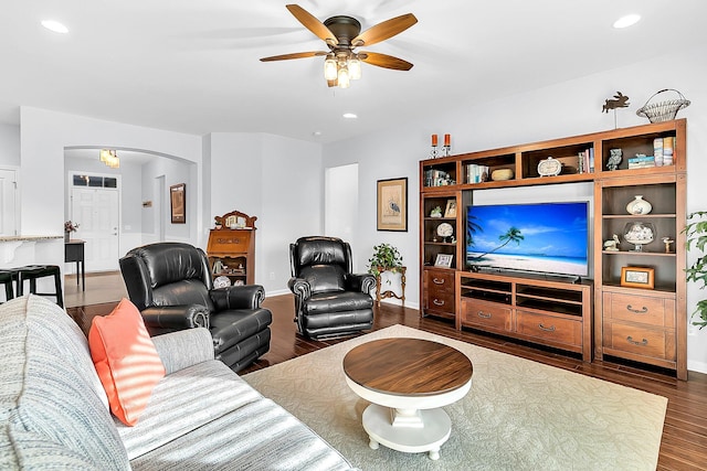 living room featuring ceiling fan and dark hardwood / wood-style floors