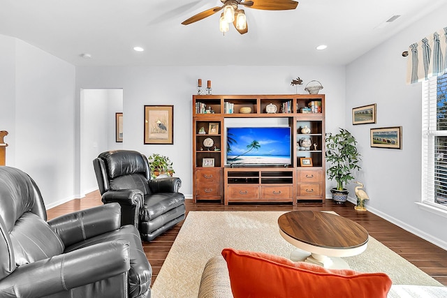 living room featuring ceiling fan and dark hardwood / wood-style floors