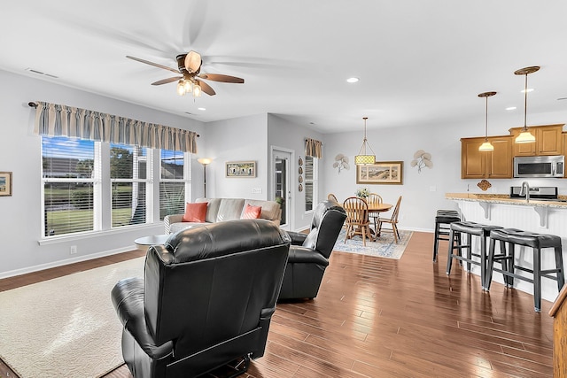 living room with ceiling fan, dark hardwood / wood-style flooring, and sink