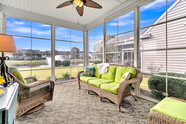 sunroom / solarium with a water view and ceiling fan