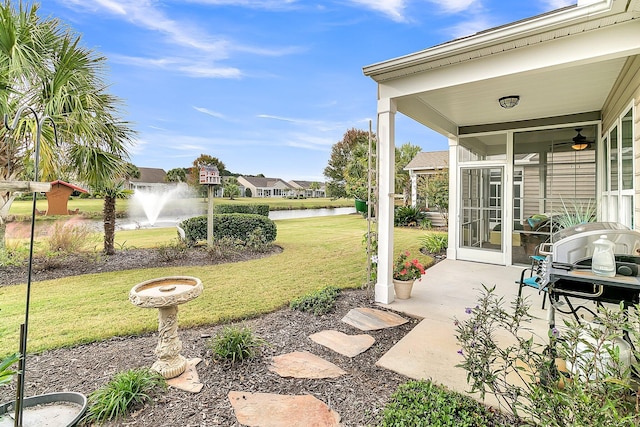 view of yard featuring a water view and ceiling fan