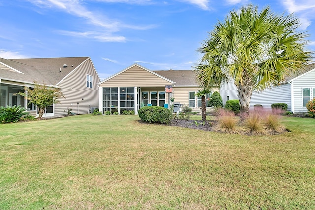 back of house featuring a lawn and a sunroom