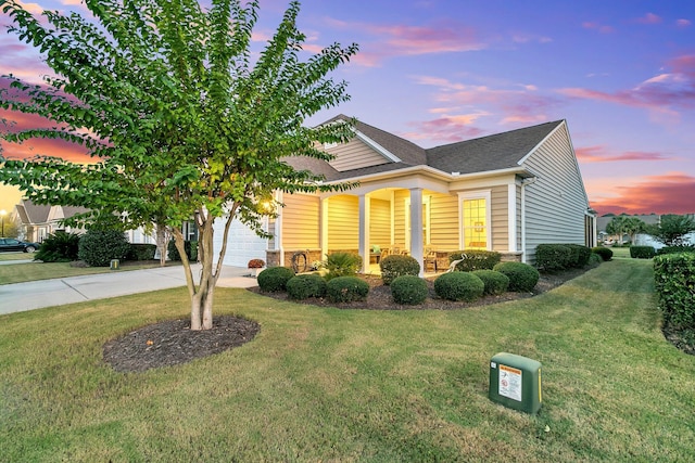 view of front of home with a garage and a yard